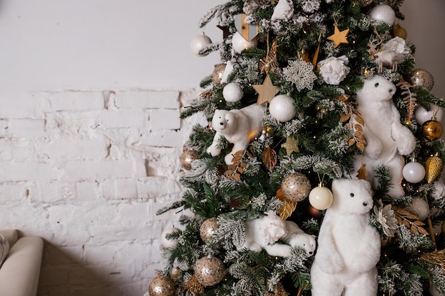 Beau grand sapin de Noël décoré de boules et de jouetscadeaux d'ambiance de Noël de vacances avec des rubansSapin de Noël décoré d'un arbre de peluches avec un intérieur ours polaire