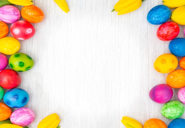 Beau groupe d'oeufs de Pâques au printemps de Pâques, oeufs rouges, bleu, violet et jaune avec des tulipes