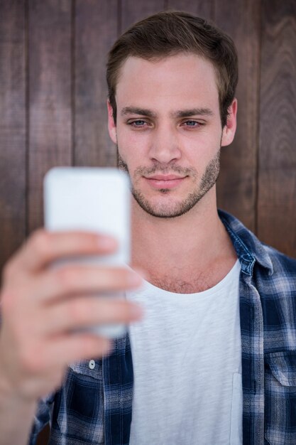 Beau hipster regardant smartphone