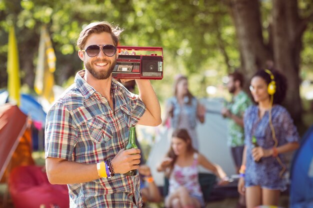 Beau hipster tenant un lecteur de cassettes rétro