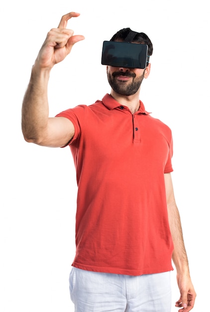 Beau homme utilisant VR glassesa et tenant quelque chose