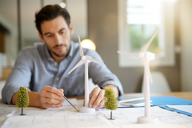 Beau ingénieur en éolienne travaillant dans un bureau moderne