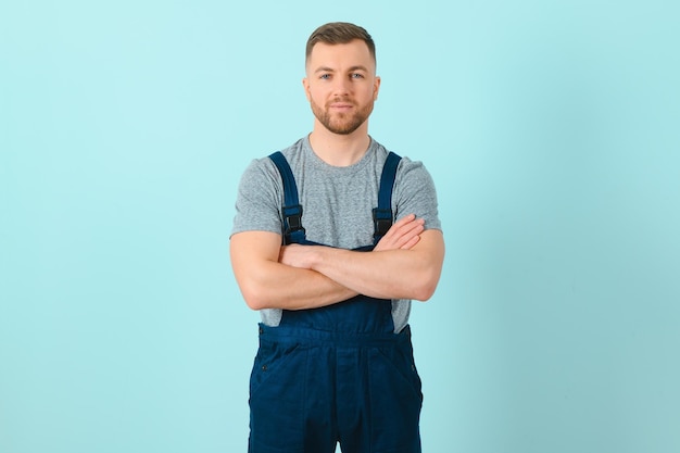 Beau jeune artisan sur fond bleu isolé