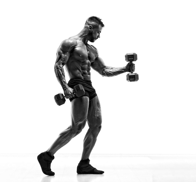 Beau jeune body builder exercice avec des haltères Image en noir et blanc