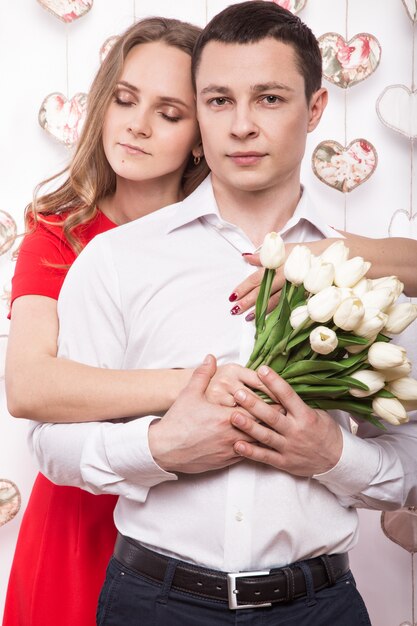 Beau jeune couple amoureux d'un bouquet de fleurs