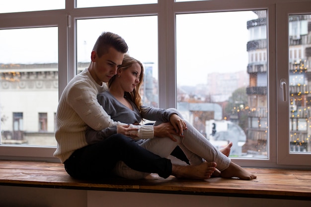 Beau jeune couple d'amoureux se liant les uns aux autres et souriant