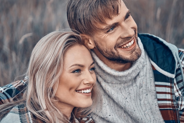 Beau jeune couple d'amoureux se liant et souriant tout en passant du temps à l'extérieur