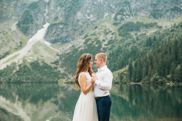 Un beau jeune couple au bord du lac dans les montagnes de Tatra en Pologne Morskie Oko