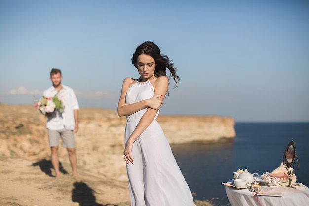 Beau jeune couple à une date. Le gars apporte des fleurs.