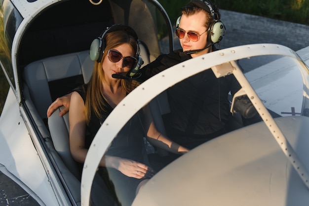 Beau jeune couple élégant en tenue officielle debout dans un avion privé