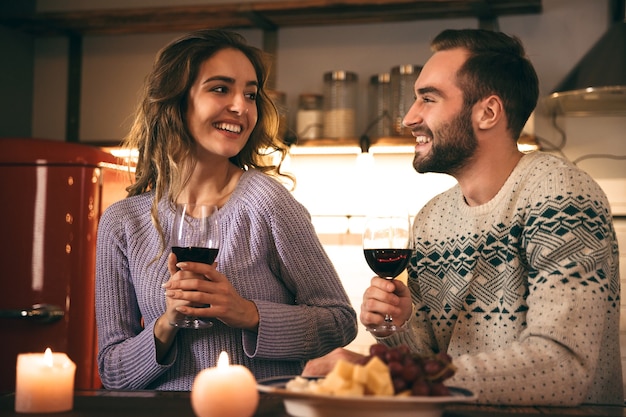 Beau jeune couple heureux, passer une soirée romantique ensemble à la maison, boire du vin rouge, griller