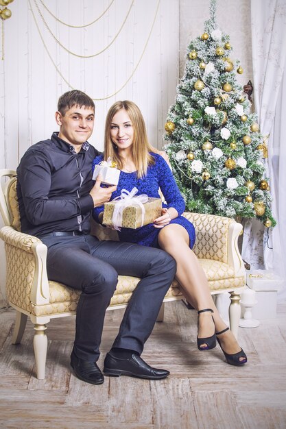 Beau jeune couple homme et femme ensemble dans le joyeux Noël