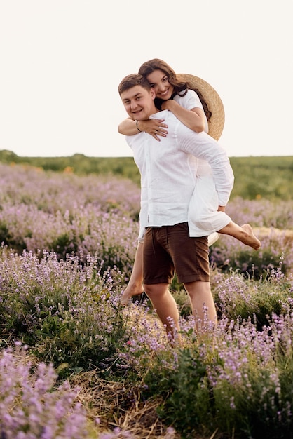 Beau jeune couple marchant sur un champ de lavande