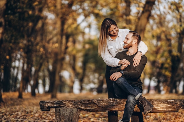 Beau jeune couple marchant dans le parc d'automne par une journée ensoleillée