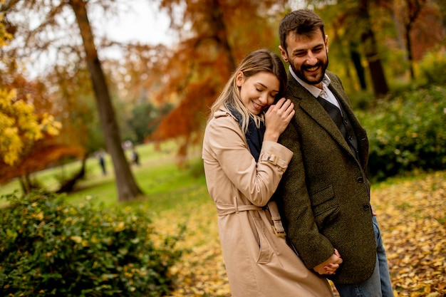 Beau jeune couple marchant dans le parc en automne