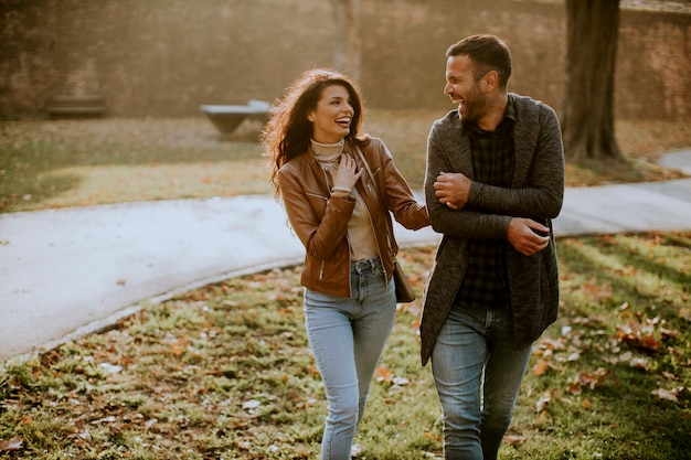 Beau jeune couple marchant dans le parc en automne