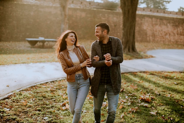 Beau jeune couple marchant dans le parc en automne