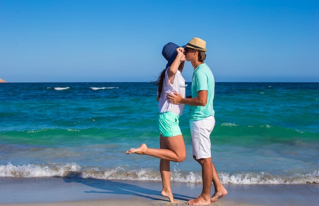 Beau jeune couple marchant sur la plage pendant des vacances tropicales