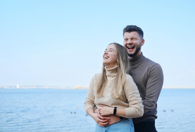 Beau jeune couple marié posant sur la plage Homme et femme riant et étreignant