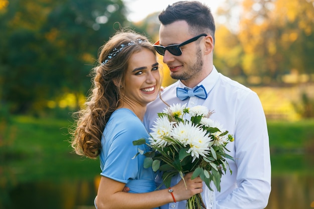 Beau jeune couple posant sur la cérémonie de mariage