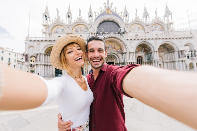 Beau jeune couple prenant un selfie à Venise, Italie sur la Piazza San Marco. Heureuse femme et homme amoureux voyageant ensemble.