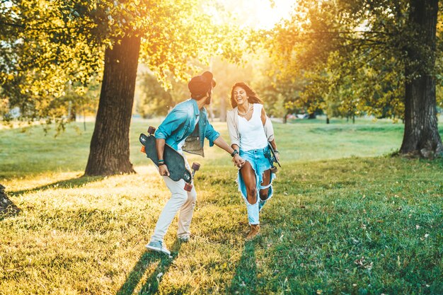 Beau jeune couple profitant de l'extérieur dans le parc de skate de la ville.