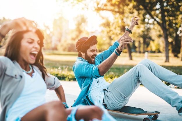 Photo beau jeune couple profitant de l'extérieur dans le parc de skate de la ville