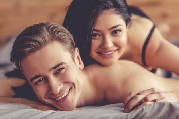 Beau jeune couple regarde la caméra et souriant.