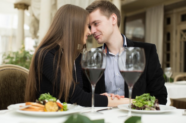 Beau jeune couple s'embrassant au restaurant