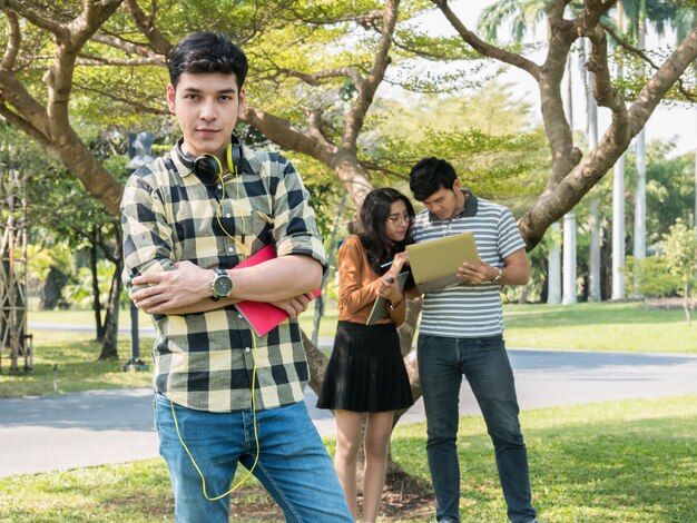 Beau jeune étudiant tenant des livres et souriant