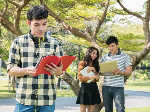 Beau jeune étudiant tenant des livres et souriant