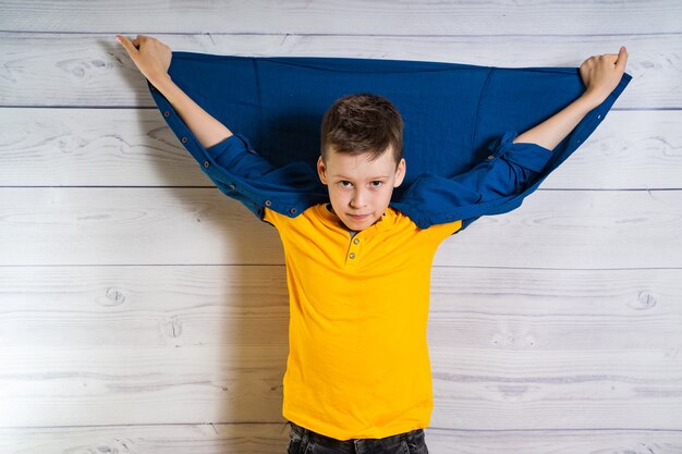 Beau jeune garçon posant à la caméra avec les mains et la veste dans le dos