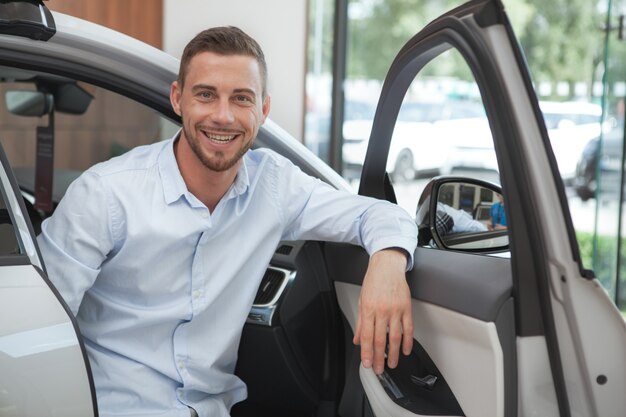 Beau jeune homme, acheter une nouvelle voiture au salon de la concession