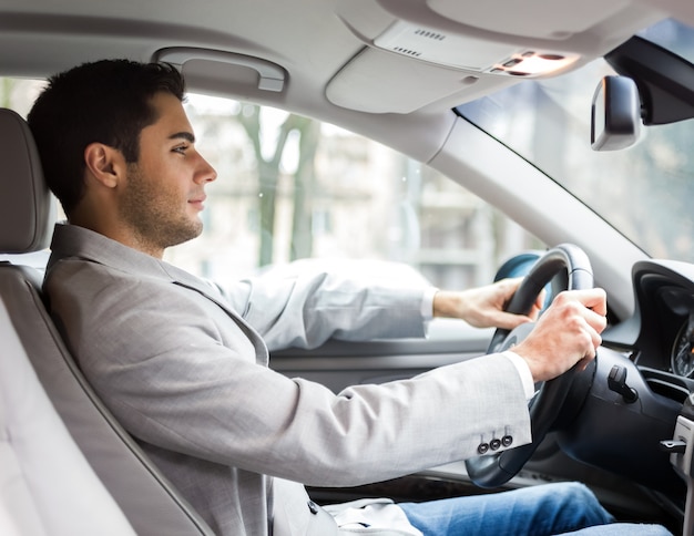 Beau jeune homme d&#39;affaires conduisant sa voiture