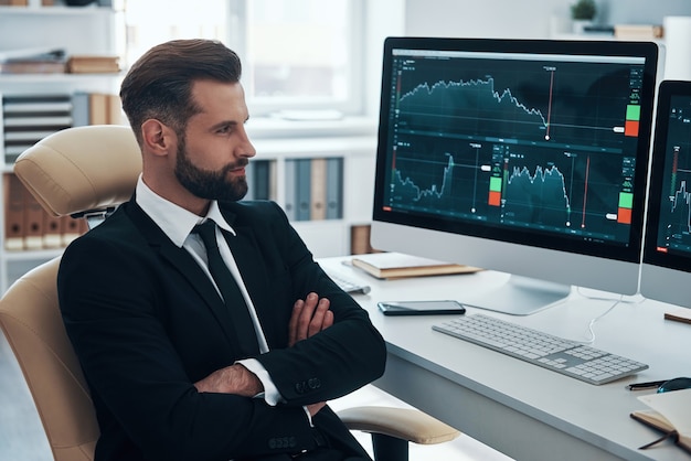 Beau jeune homme d'affaires travaillant sur le bureau