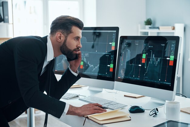 Beau jeune homme d'affaires travaillant sur le bureau