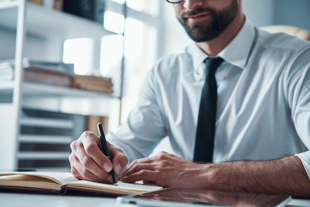 Beau jeune homme d'affaires travaillant sur le bureau