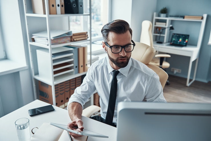 Photo beau jeune homme d'affaires travaillant sur le bureau