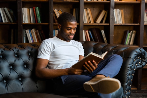 beau jeune homme africain lisant un livre