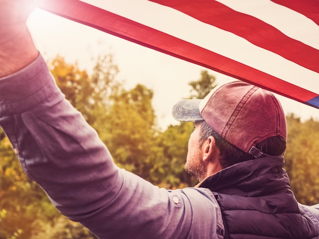 Photo beau jeune homme agitant un drapeau américain