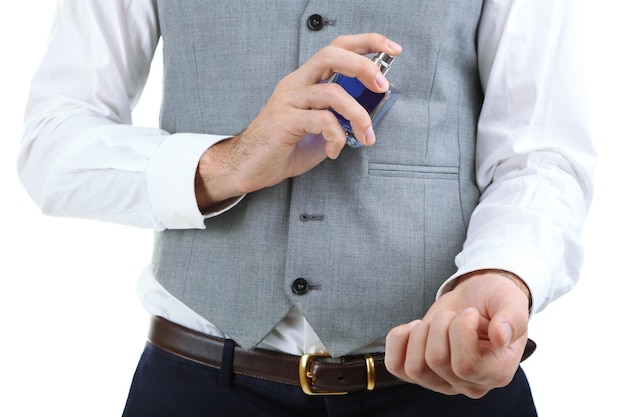 Photo beau jeune homme à l'aide de parfum isolé sur blanc