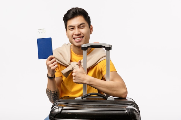 Beau Jeune Homme Asiatique En T-shirt Jaune Prêt à Voyager Avec Trolley Et Passeport