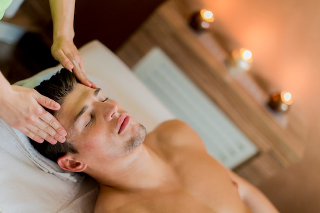 Beau jeune homme ayant un massage du visage