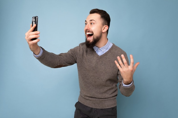 Beau jeune homme à la barbe portant un pull gris décontracté