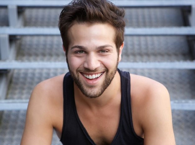 Beau jeune homme avec une barbe en souriant