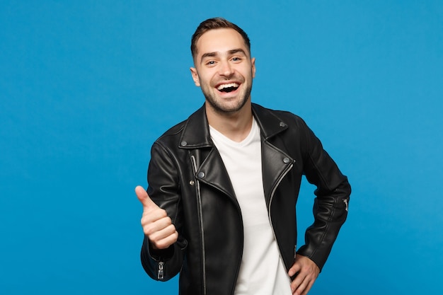 Beau jeune homme barbu élégant en veste de cuir noir t-shirt blanc à la recherche d'une caméra isolée sur fond de mur bleu portrait en studio. Concept de mode de vie des émotions sincères des gens. Maquette de l'espace de copie.