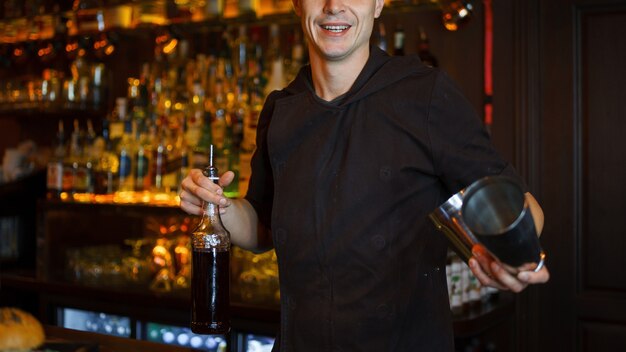 Beau Jeune Homme Barman Avec Un Sourire Fait Un Cocktail Au Bar