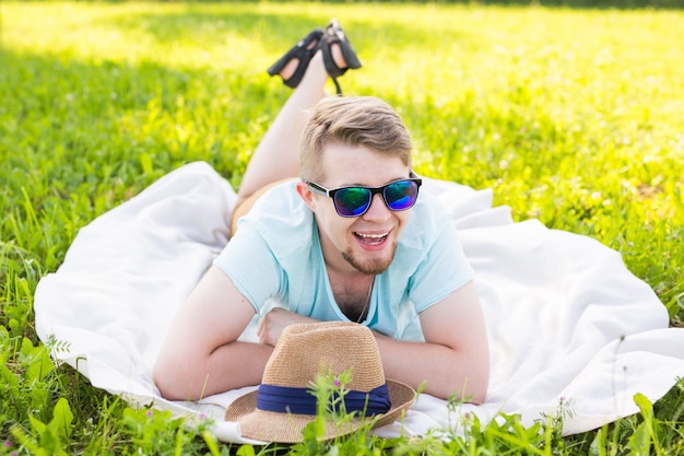 Beau jeune homme à la campagne, devant le champ portant une chemise, regardant la caméra en souriant