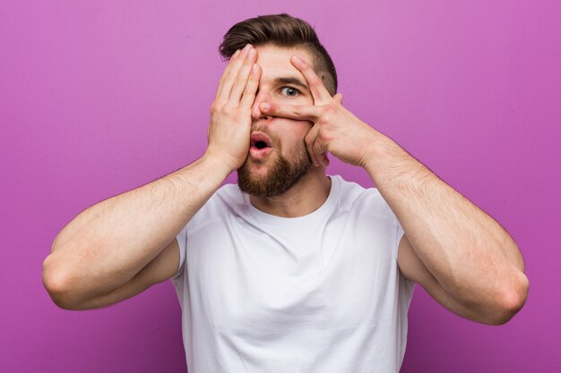 Beau jeune homme caucasien cligner des yeux effrayé et nerveux.