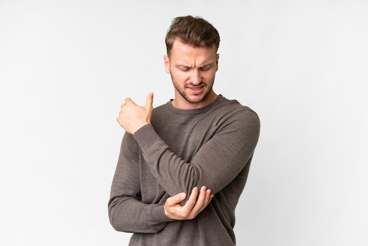 Photo beau jeune homme caucasien sur fond blanc isolé avec douleur au coude